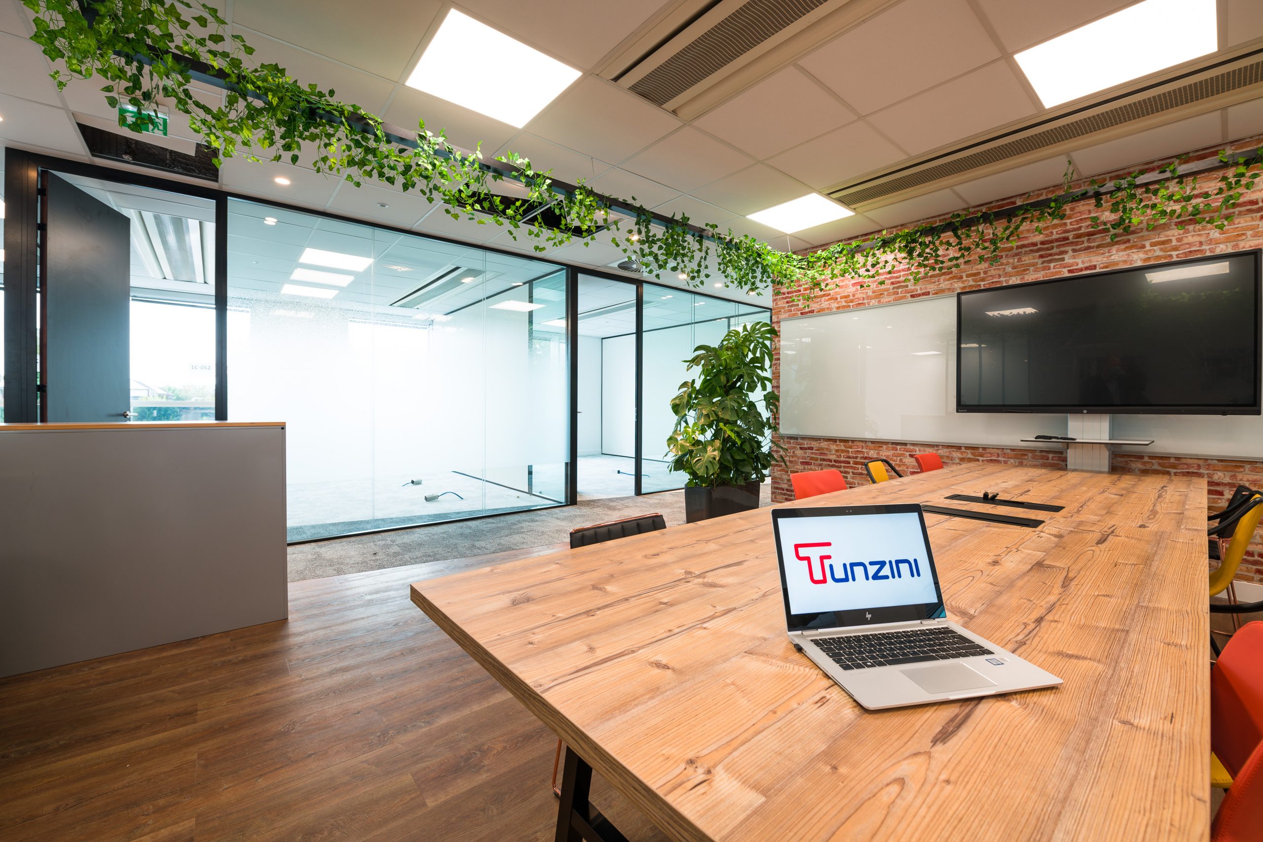 ordinateur portable avec logo tunzini posé sur une table dans locaux tunzini